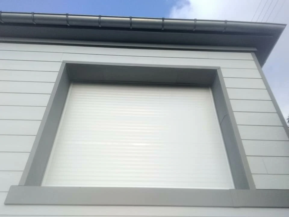 Façade d'une maison avec bardage en bois et pierres apparentes. Couverture Delalande, bardage et rénovation de maisons traditionnelles en Ille-et-Vilaine.