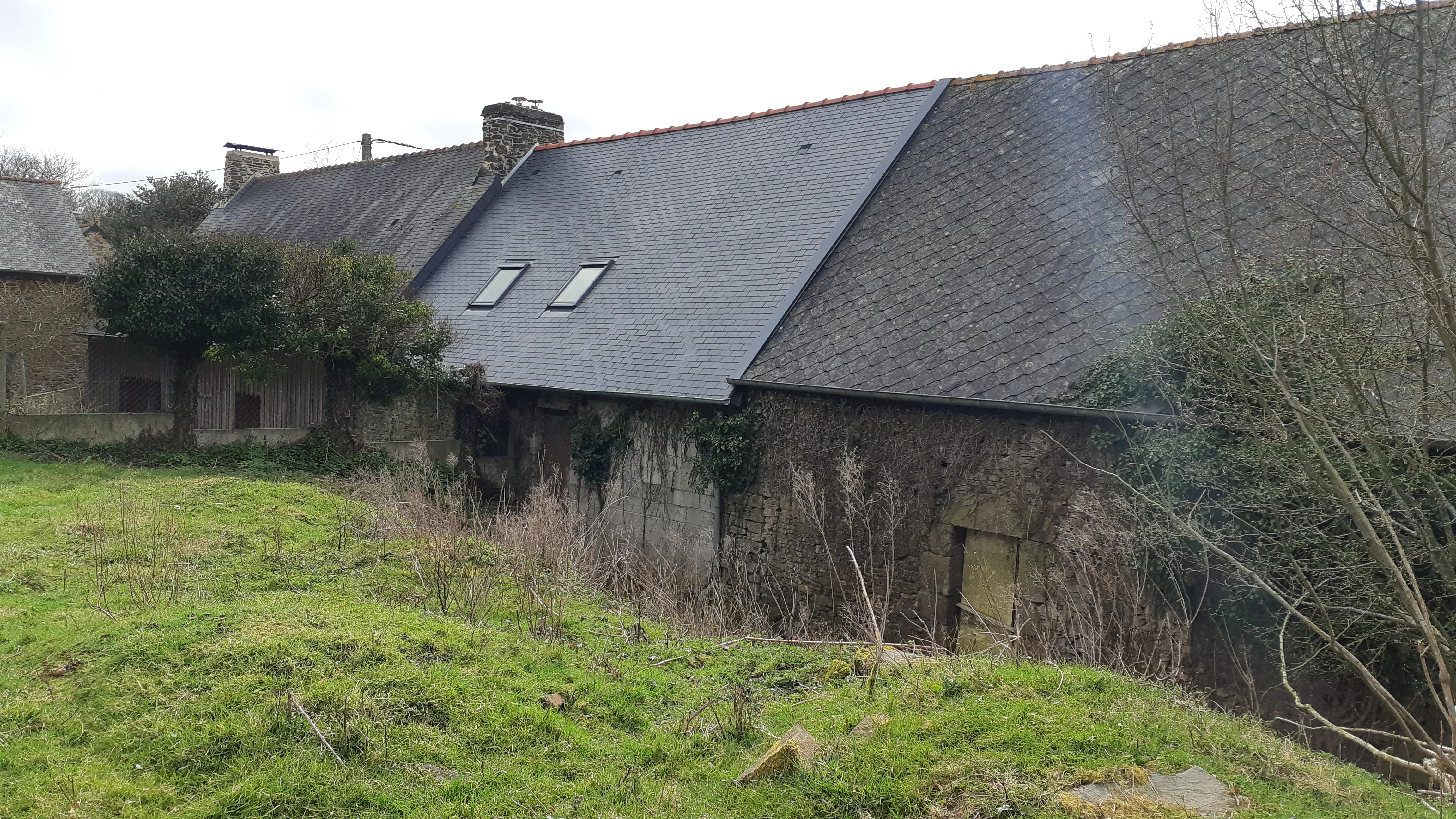 Rénovation d'une toiture en ardoise sur une longère en pierre. Couverture Delalande, expert en toitures traditionnelles en Ille-et-Vilaine.