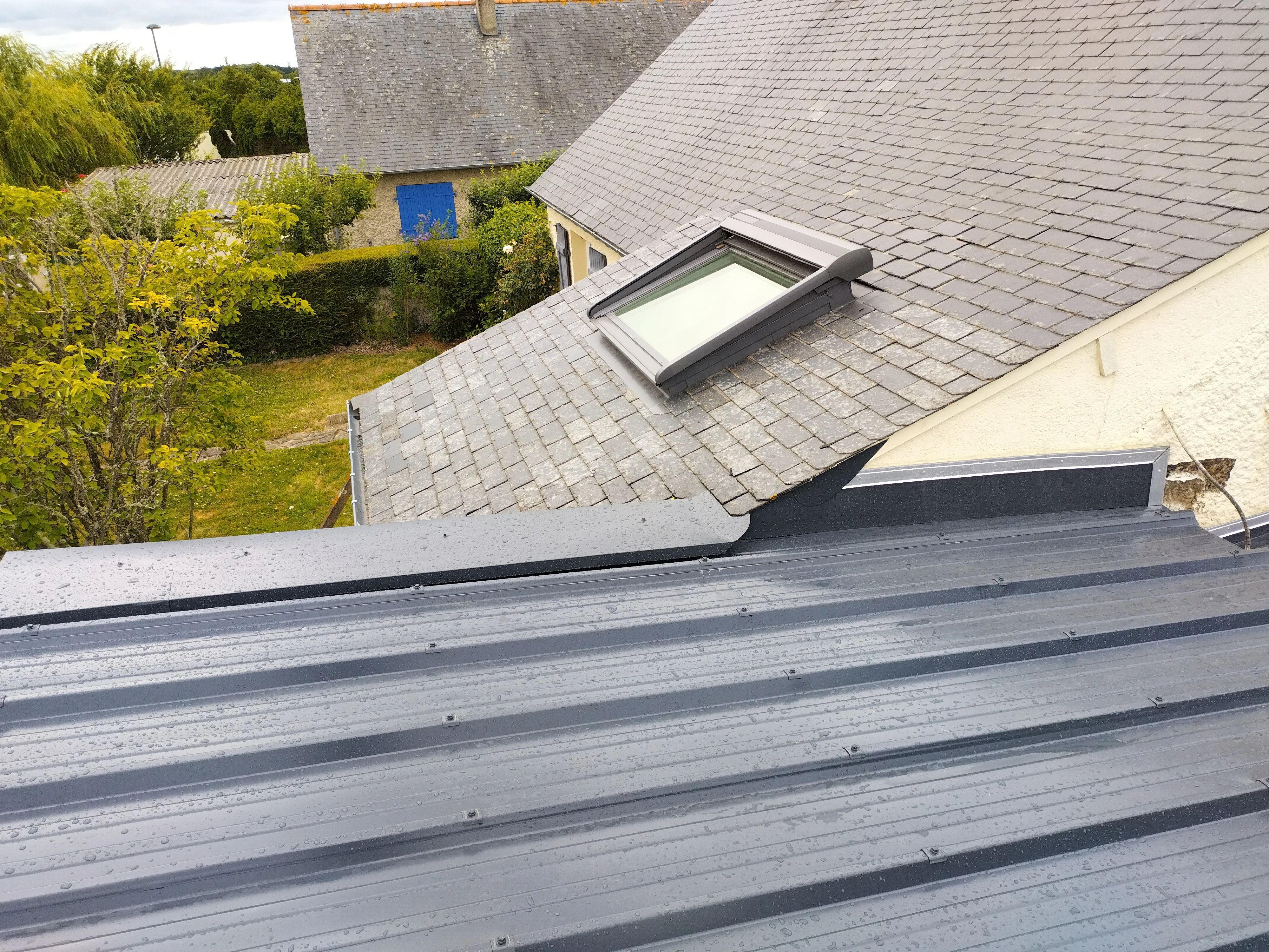 Toiture métallique récemment installée avec une lucarne de toit pour un meilleur éclairage naturel par Couverture Delalande.