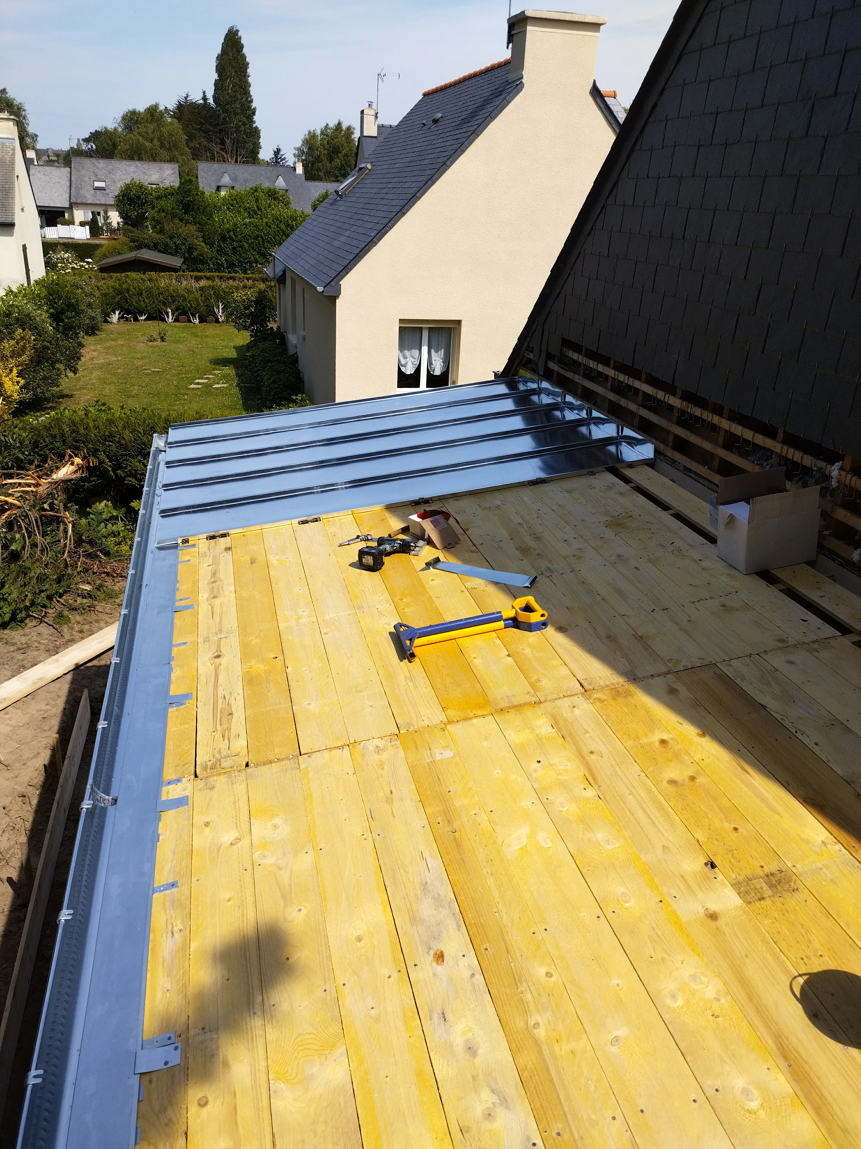 Pose d'une toiture en métal avec finition impeccable et installation d'une lucarne pour une lumière naturelle par Couverture Delalande.